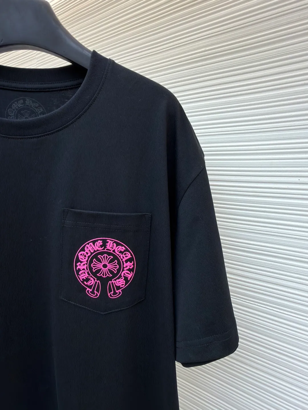 Chrome Hearts horseshoe pink T-shirt ●Item number: 1682508-X85 ●Fabric: cotton fabric ●Technology: hand-printed with ink ●Color: black ●Version: loose fit ●Weight: about 290 grams ●Size: S-M-L ●Description: This Chrome Hearts pocket printed short-sleeves are made of high-count double yarn cotton, with a weight of 320g. The fabric has been pre-washed to achieve a soft and skin-friendly touch. At the same time, it avoids shrinkage and fading problems from the root, and maintains a crisp shape after long-term wear. The body adopts seamless cylinder weaving technology, and there are no seams on the sides, so there is no sense of restraint when worn. The shoulders are classic dropped shoulders, and the loose body shape is suitable for all kinds of body shapes. The rose-red totem print on the left breast pocket is made of imported environmentally friendly slurry and produced through a high-precision screen printing process. The printing has clear layers and saturated colors, and it is not easy to crack or fall off after repeated washing. The neckline adopts a double-needle reinforced hemming design and is paired with a customized threaded collar, which is durable and not easily deformed. The overall wiring follows luxury craftsmanship standards, and the stitching is even and fine. Every detail demonstrates ingenuity. Customized hardware and accessories are complete with three logos, restoring the classic texture of the brand. The overall wiring is straight and delicate, the fabric is comfortable and soft, and the color is consistent without color difference. It can be matched with the same style to create a fashionable look and control various occasions. Customized accessories, complete with three standards, same style for men and women!
